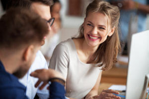 Smiling,Happy,Young,Woman,Talking,With,Male,Colleagues,At,Shared
